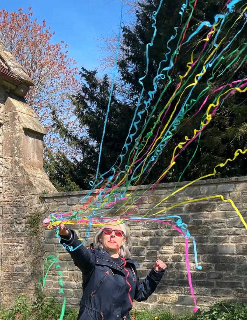 Multi-colour paper streamers thrown from a hand streamer.