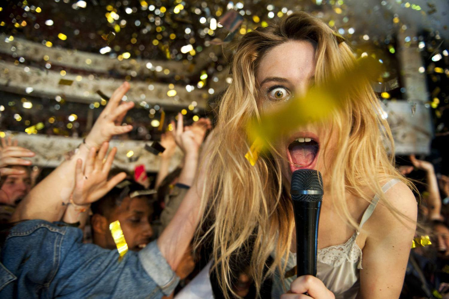 Gold confetti over crowd at music concert.